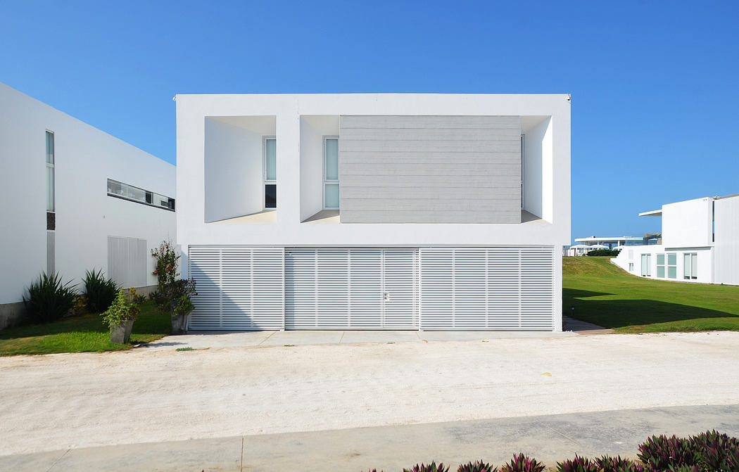 Modern white minimalist house with large windows and garage door.