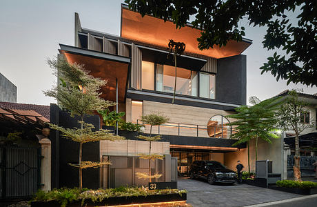 Modern multi-level house with large windows and a car parked outside.