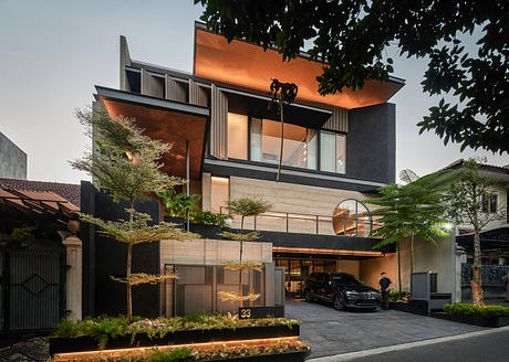 Modern multi-level house with large windows and a car parked outside.