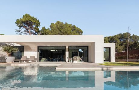 Contemporary home with large pool and flat roof design.