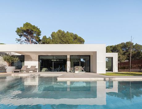 Contemporary home with large pool and flat roof design.