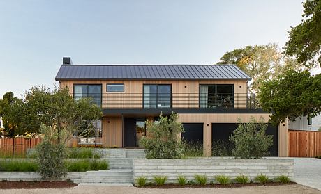 Modern two-story house with a metal roof and wooden siding.