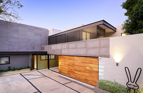 Contemporary house facade at dusk with wooden garage door.