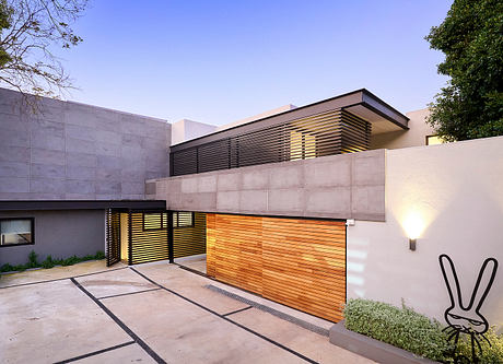 Contemporary house facade at dusk with wooden garage door.