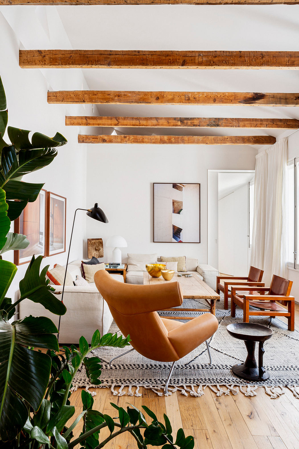 Modern living room with exposed wooden beams and stylish furniture.