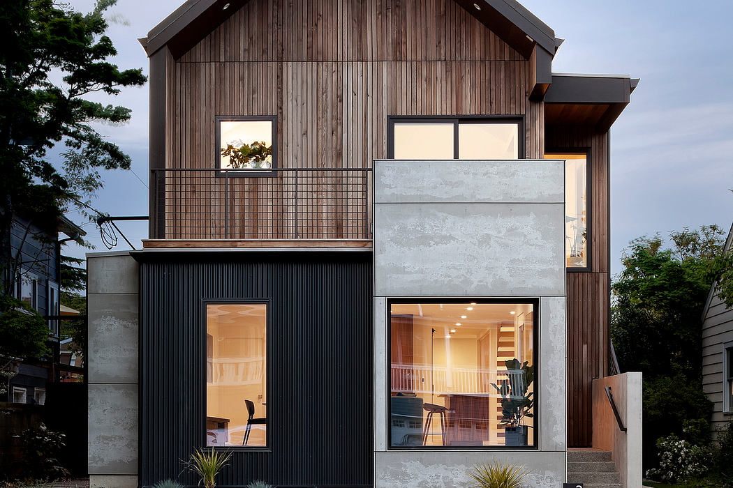 Contemporary two-story home with mixed-material facade and warm lighting.