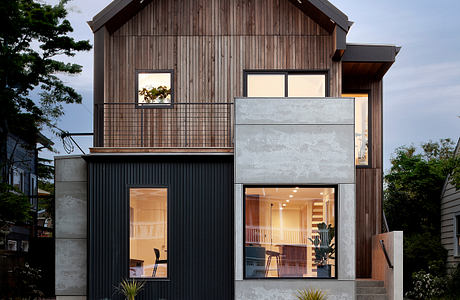 Contemporary two-story home with mixed-material facade and warm lighting.