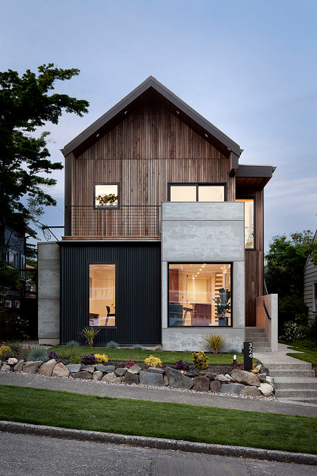 Contemporary two-story home with mixed-material facade and warm lighting.