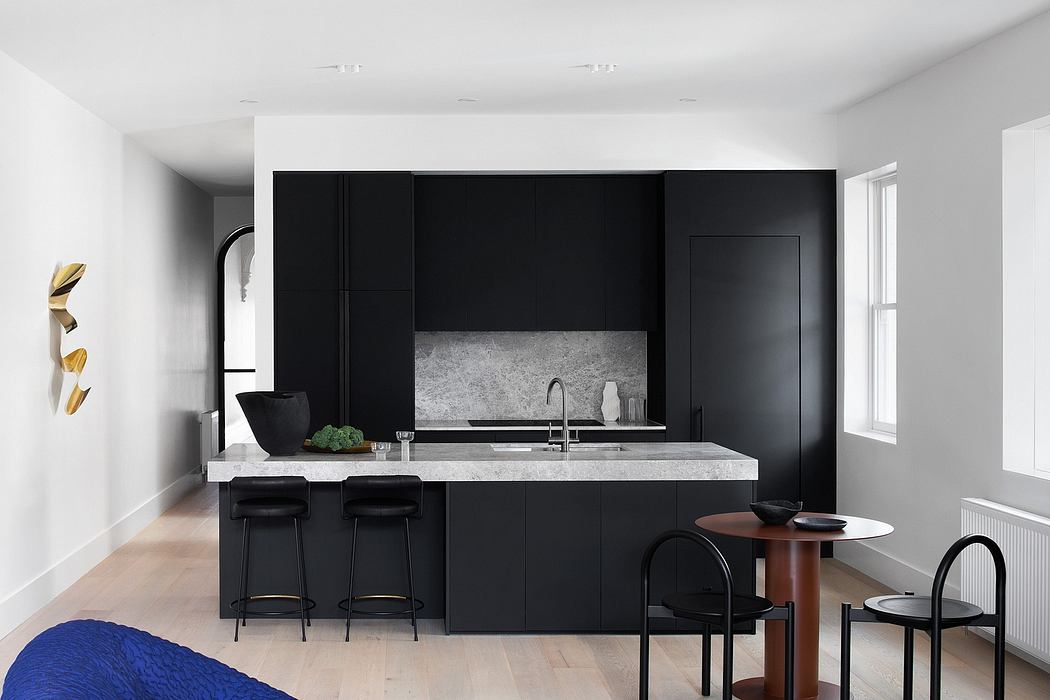 Sleek kitchen with black cabinetry and marble backsplash, flanked by