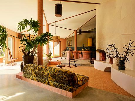 Contemporary room with earth tones, patterned sofa, and indoor plants.