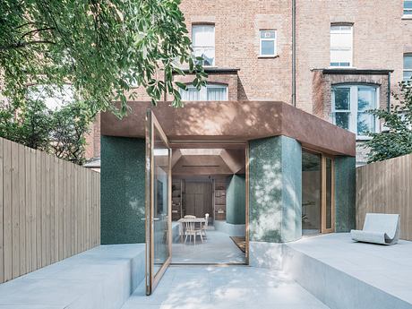 Modern house extension with large glass doors and a minimalist patio.