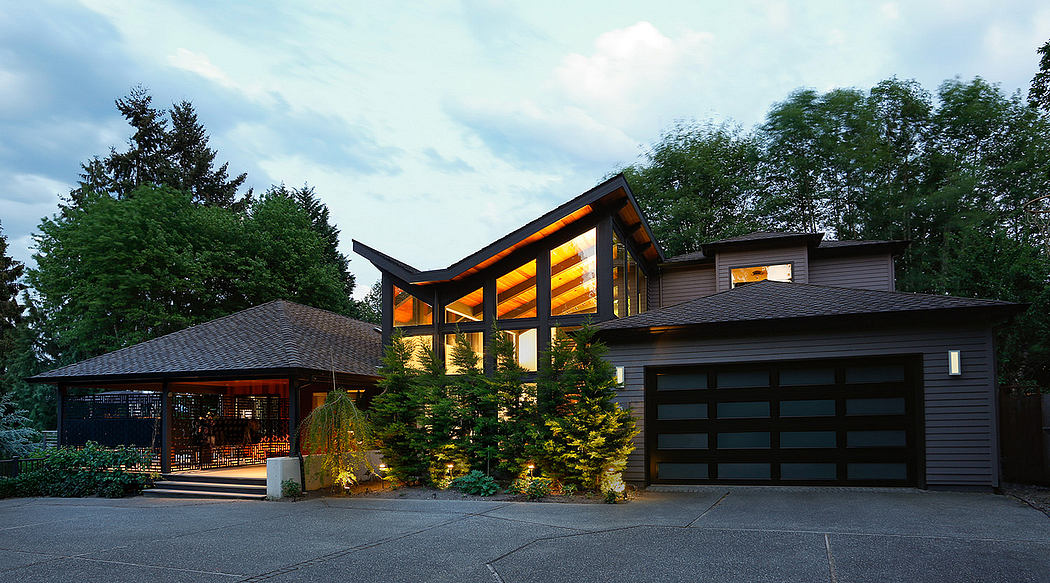 Contemporary house with illuminated windows at dusk and a double garage.