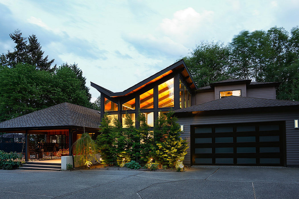 Contemporary house with illuminated windows at dusk and a double garage.