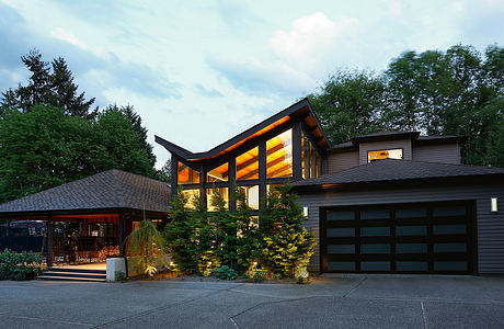 Contemporary house with illuminated windows at dusk and a double garage.