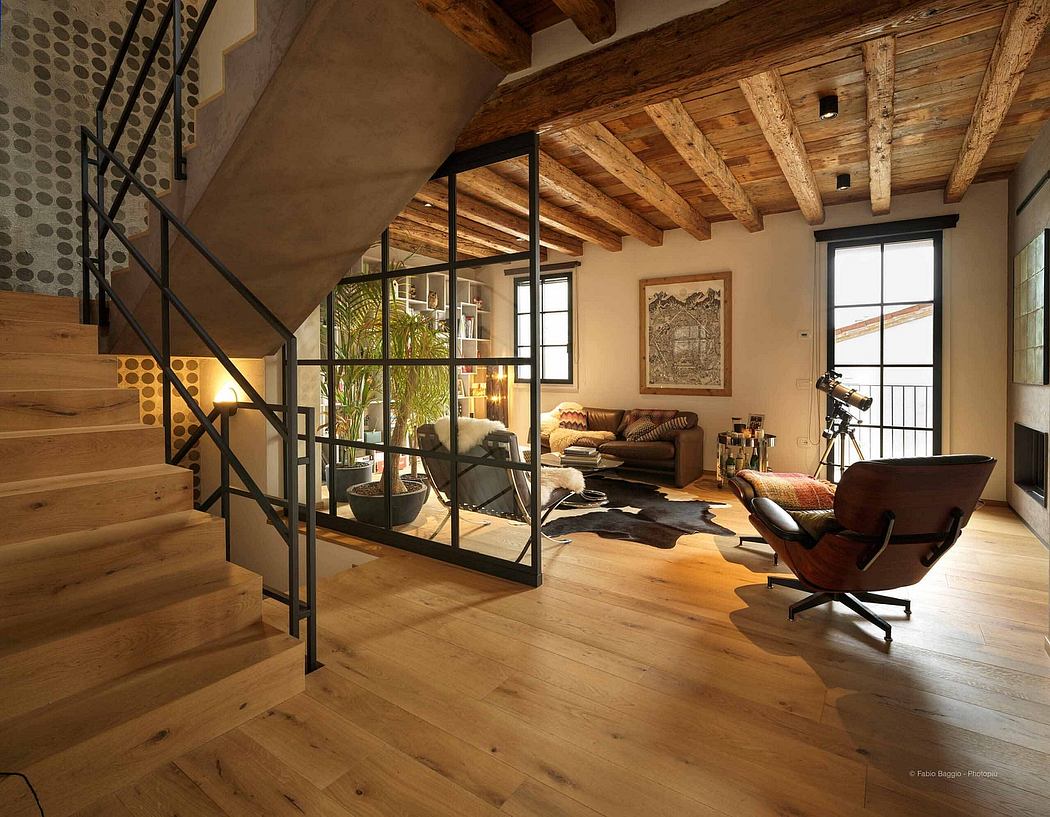 Rustic-chic living space with exposed beams and a sleek staircase.