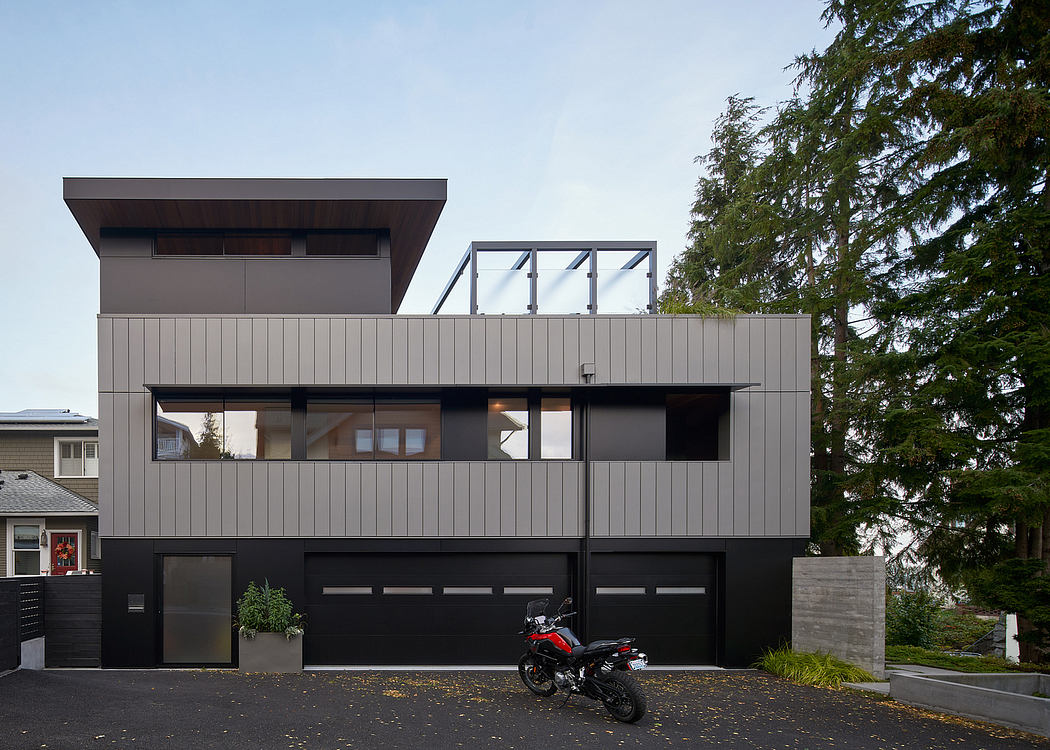 Modern two-story house with large windows and a motorcycle parked outside.