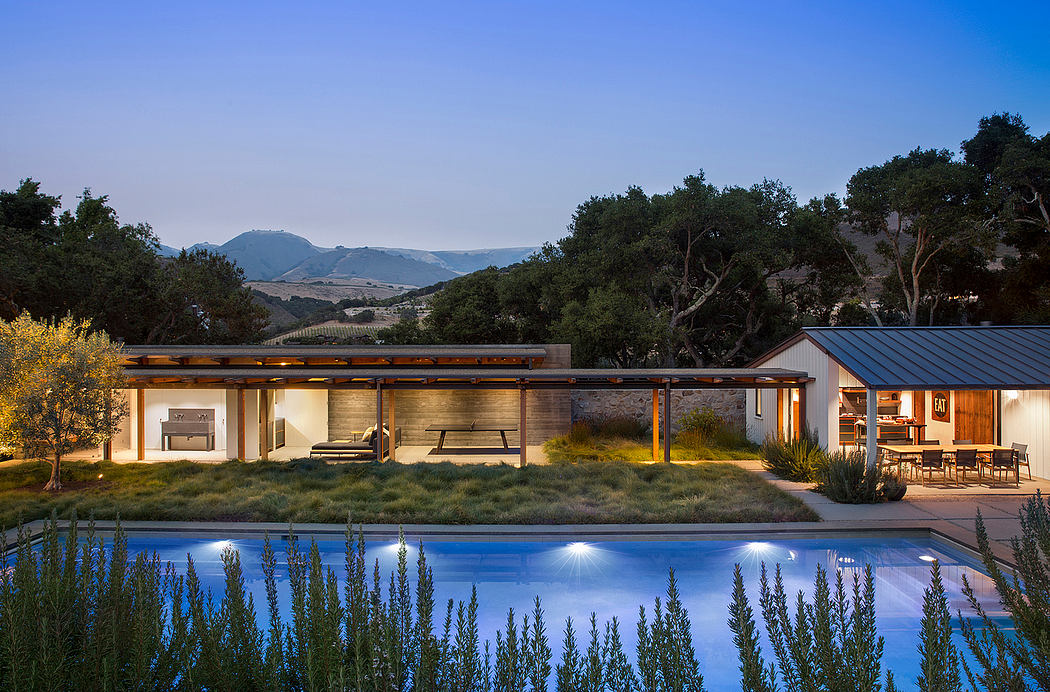 Contemporary house with pool at dusk, surrounded by nature.
