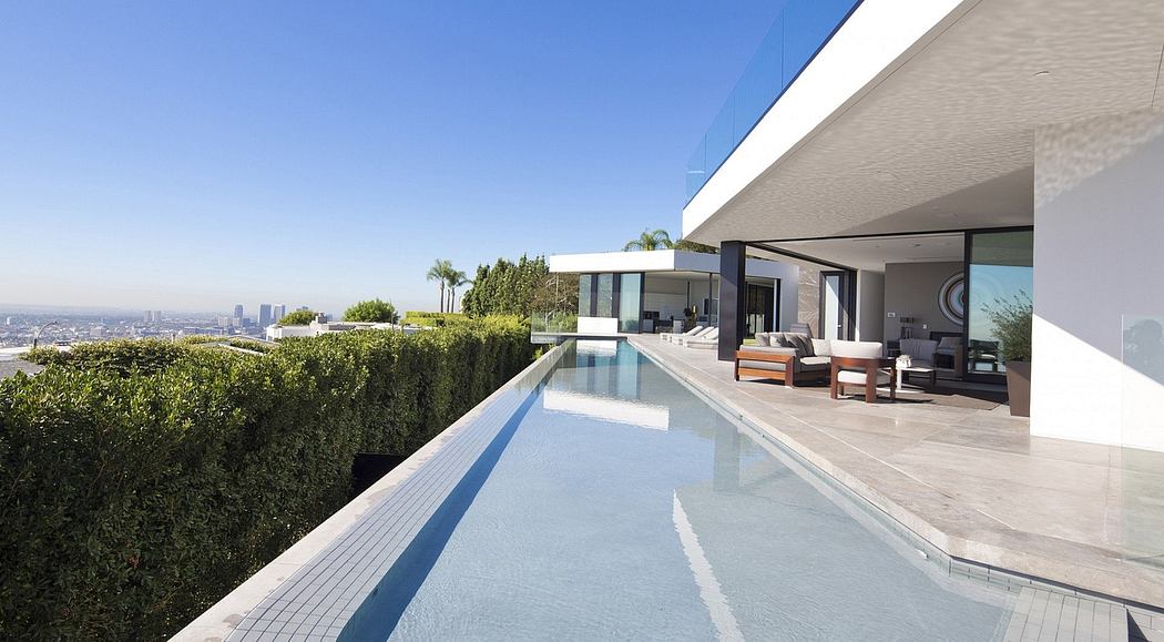 Contemporary home with infinity pool overlooking a cityscape.