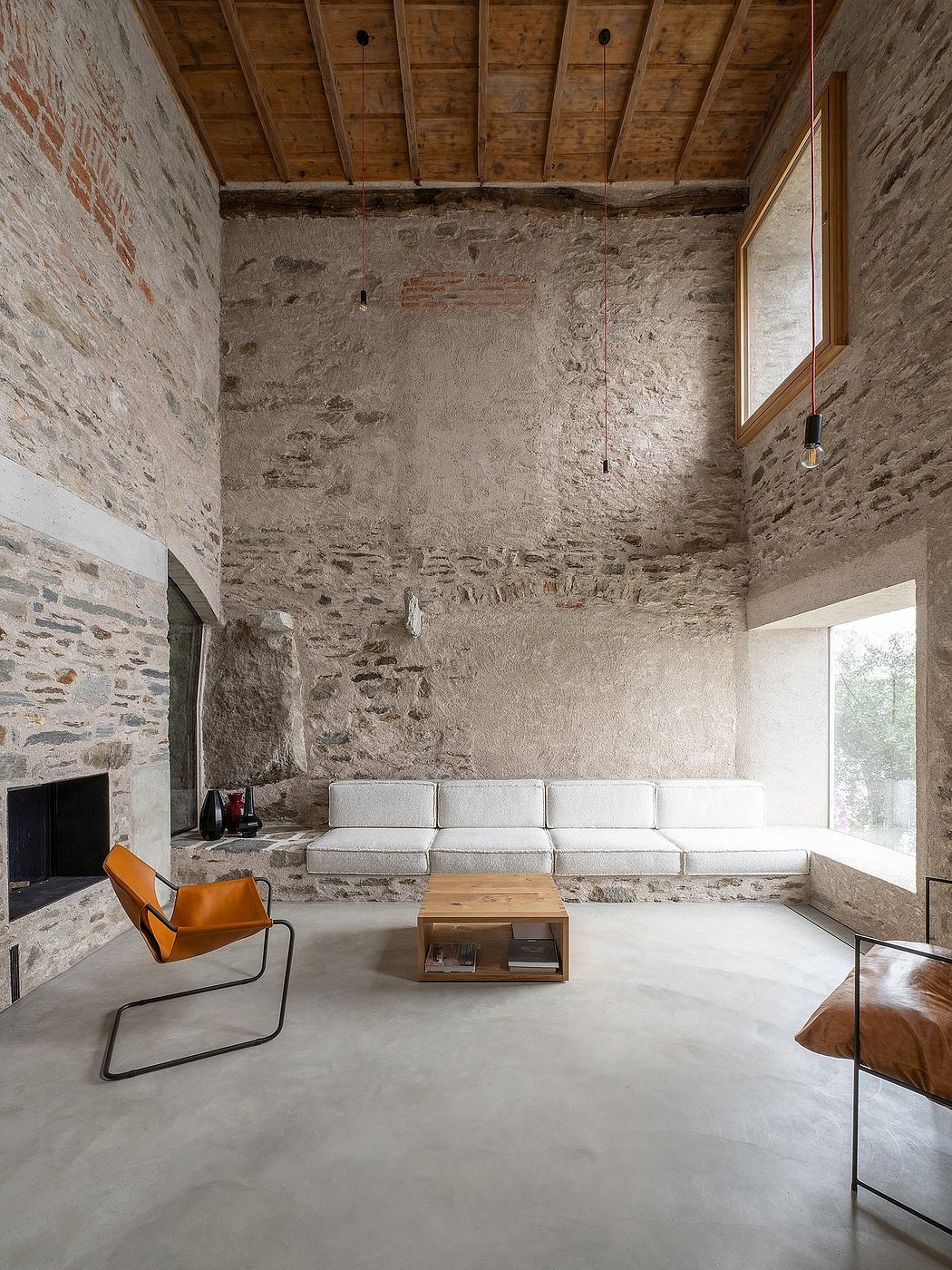 Contemporary room with exposed stone walls, wooden ceiling, and minimalistic furniture.