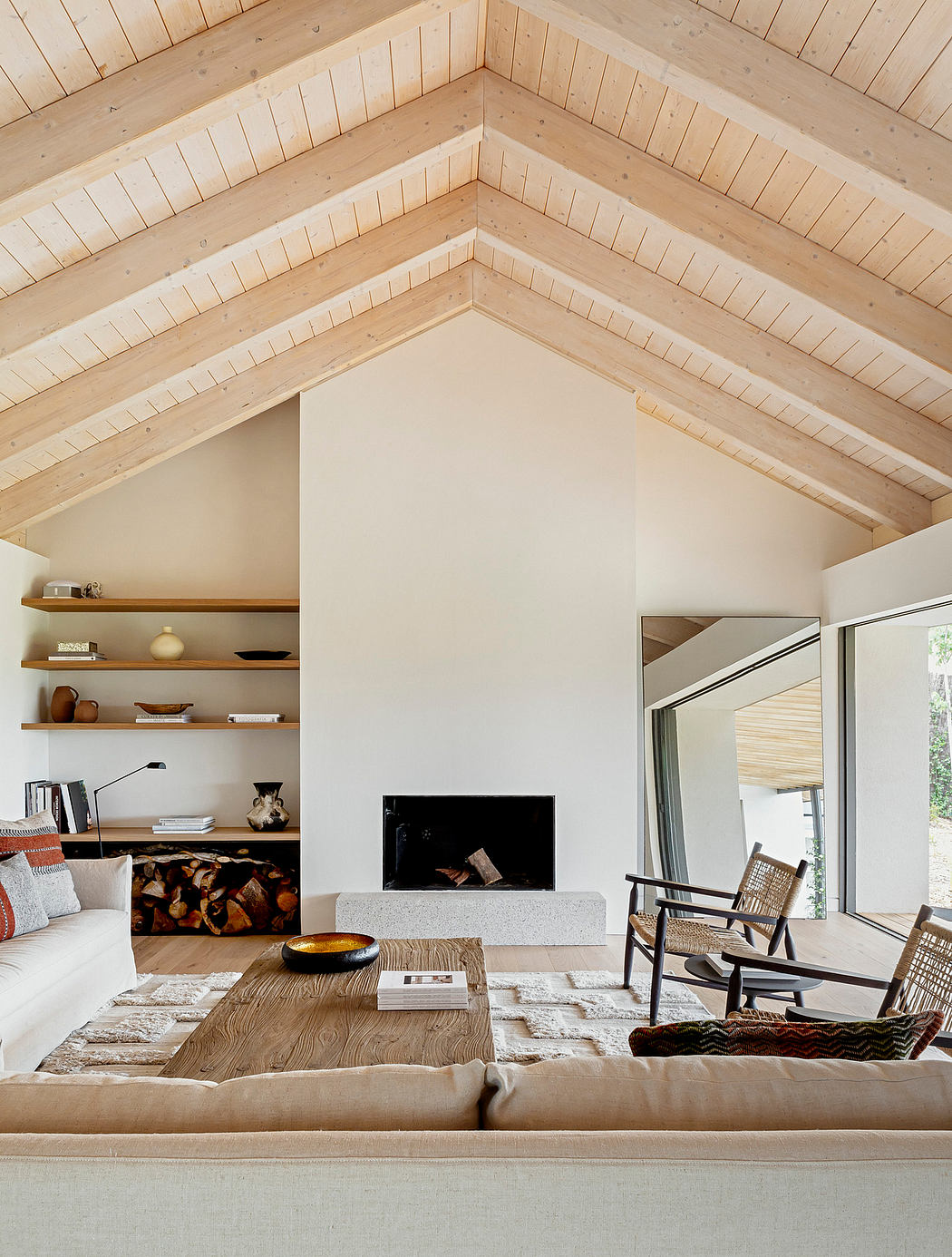 Contemporary living room with A-frame ceiling, fireplace, and wooden accents.