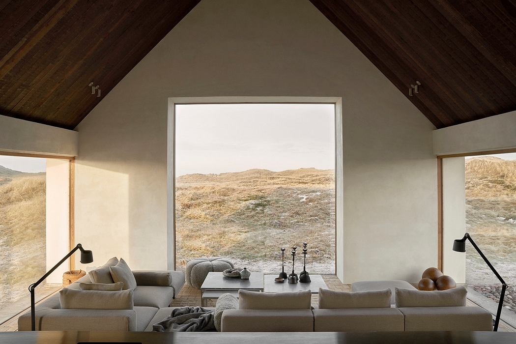 Minimalist living room with large window overlooking a hilly landscape.