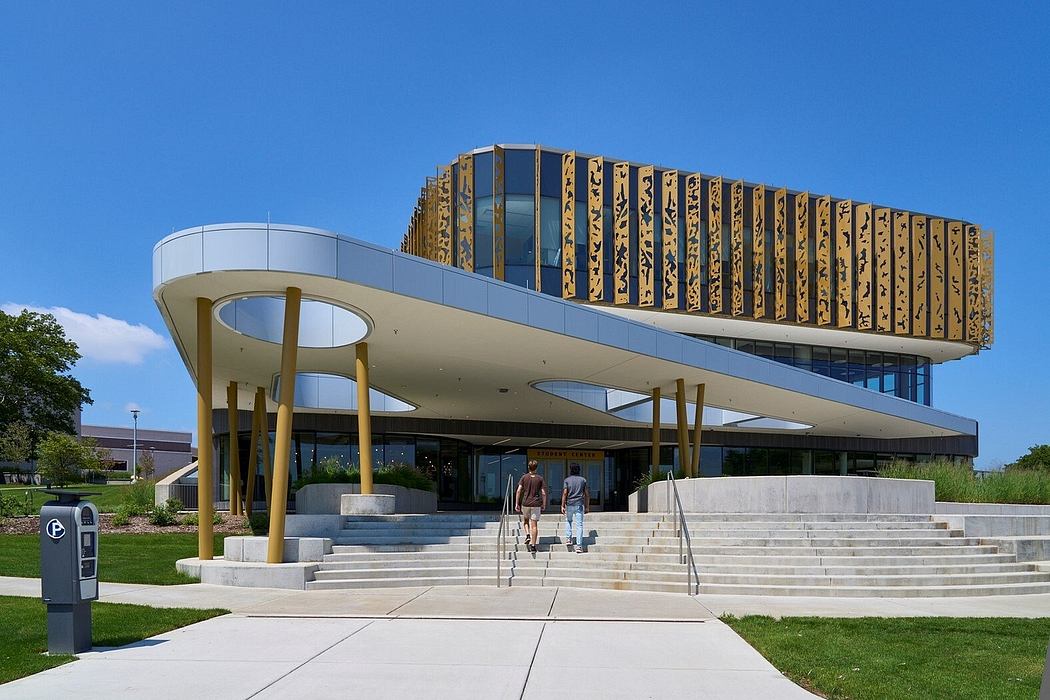Contemporary building with elevated, patterned upper level and sweeping canopy entrance.