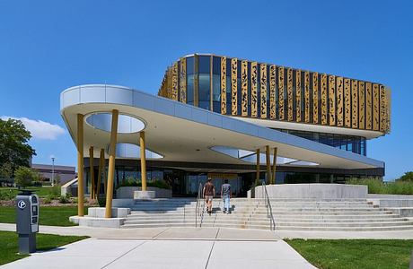 Contemporary building with elevated, patterned upper level and sweeping canopy entrance.