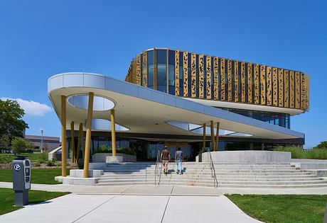 Contemporary building with elevated, patterned upper level and sweeping canopy entrance.