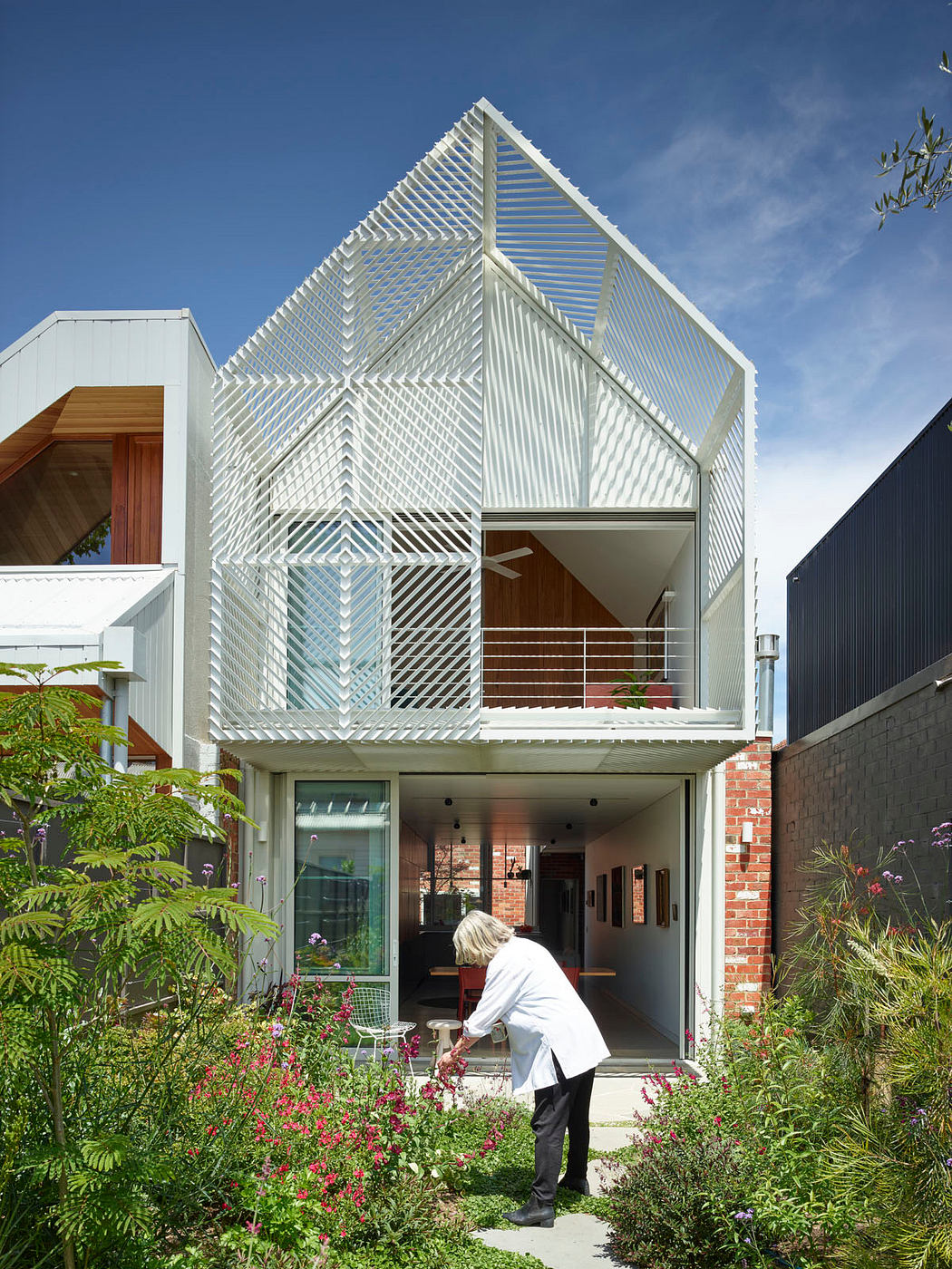 Contemporary house with a geometric facade and lush garden.