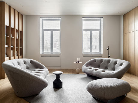 Modern room with two designer chairs and wooden shelving.