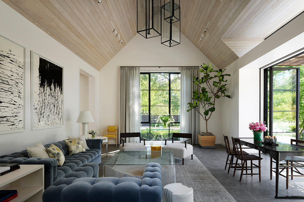 Stylish living room with vaulted ceiling, large windows, and chic furnishings