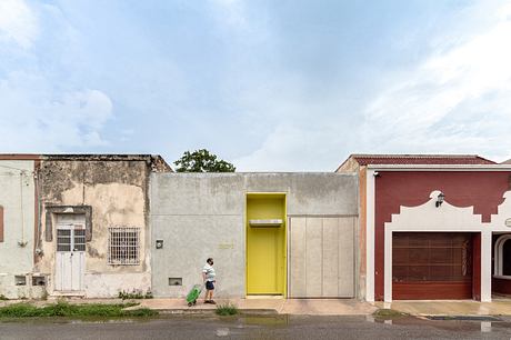 Three adjacent houses with varying facades, one with a bright yellow door.