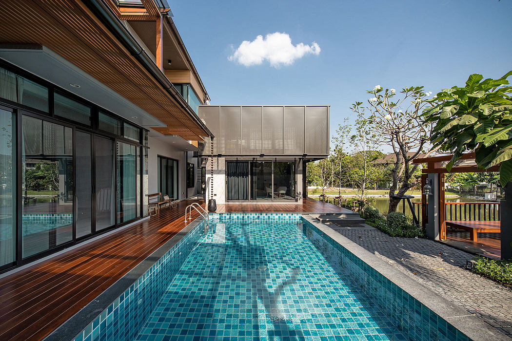 Contemporary home with pool and wood deck under clear skies.