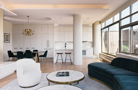 Modern living room with white walls, large windows, and stylish furniture.