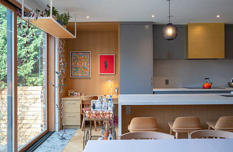 Modern kitchen with dining area and large window.