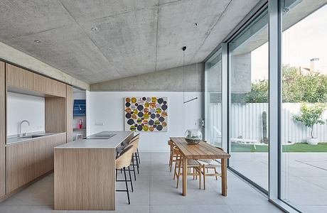 Minimalist kitchen with concrete ceiling, wooden furniture, and floor-to-ceiling windows