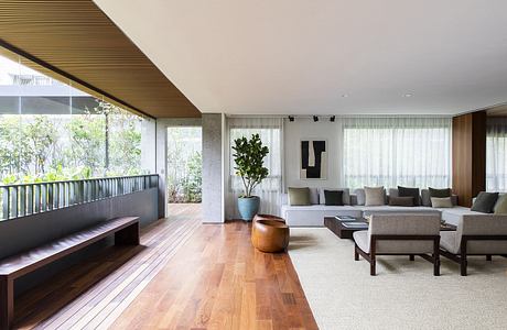 Contemporary living room with wooden floors and large windows.