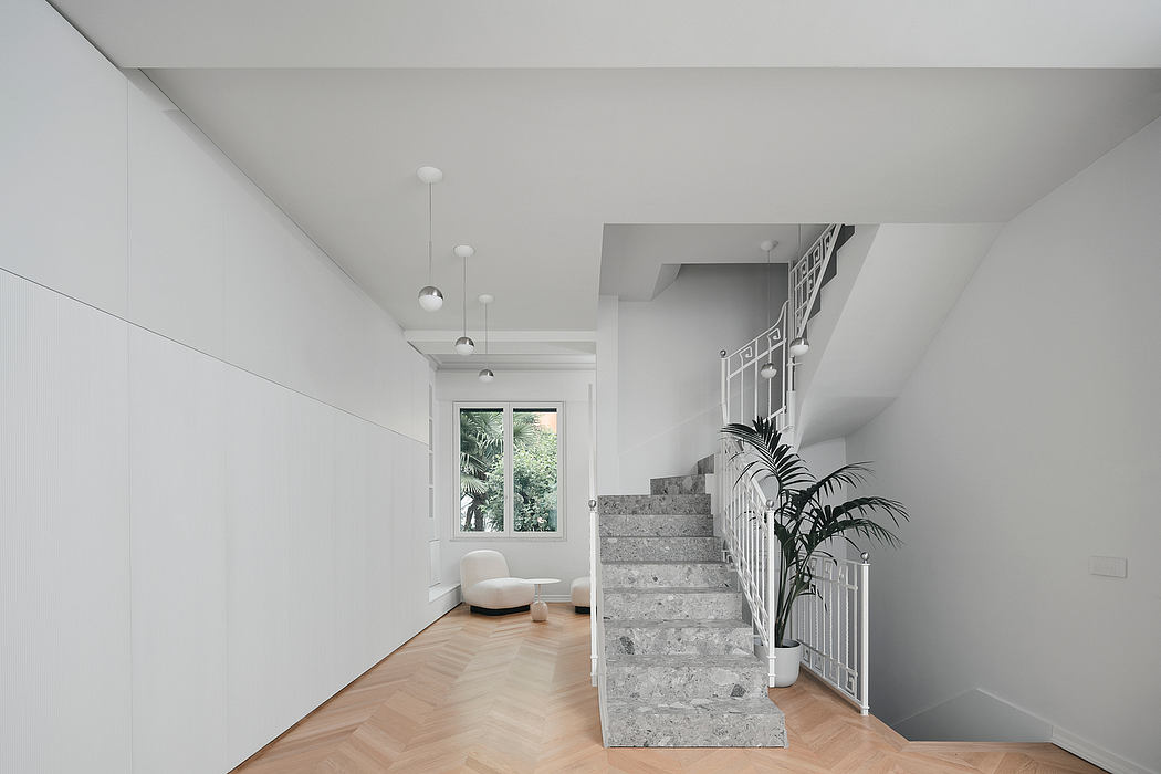 Minimalist interior with white walls, wooden floor, and gray staircase.
