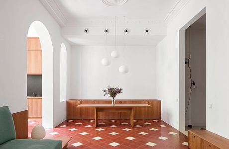 Minimalist interior with white walls, archway, and checkered floor.