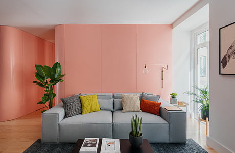 Contemporary living room with coral walls and a gray sectional sofa.