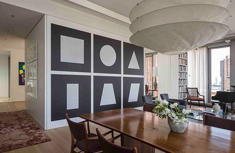 Contemporary dining room with geometric wall art and circular pendant light.