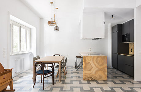 Modern kitchen with geometric floor and wooden dining table.