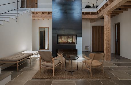 Modern living room with fireplace, wooden beams, and minimalist furniture.