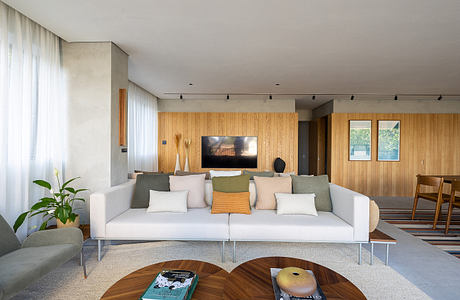 Modern living room with wooden walls, a large sofa, and a flat-screen TV