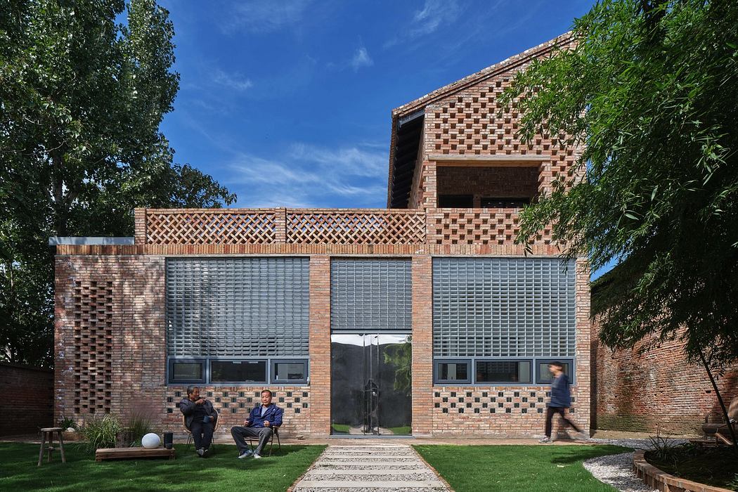 Modern brick house with patterned facade and large windows, set in a lush garden