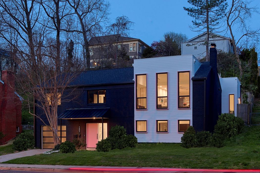 Modern two-story house with illuminated windows at twilight.