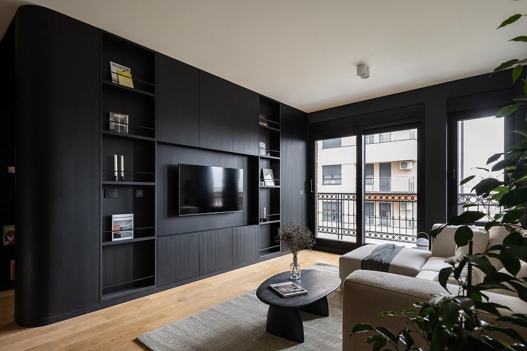 Modern living room with black built-in shelves, a gray sofa, and a balcony