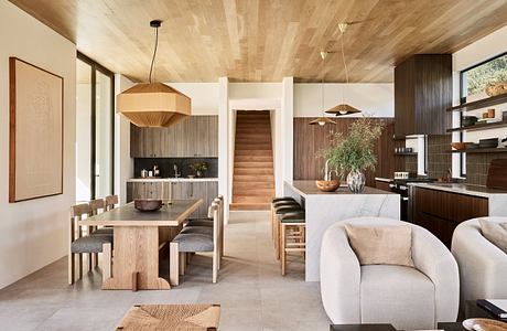 Modern open-plan living space with wooden furniture and neutral tones.