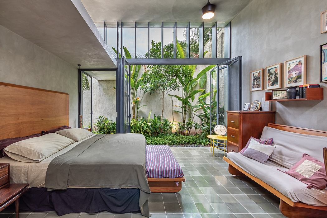 Contemporary bedroom with adjoining indoor garden and glass walls.