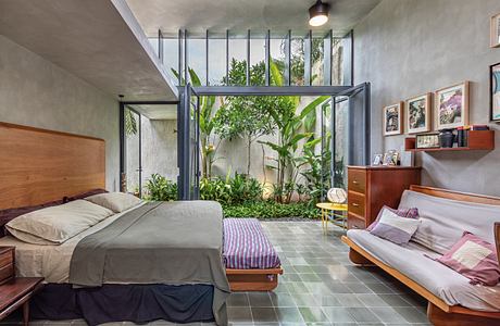 Contemporary bedroom with adjoining indoor garden and glass walls.